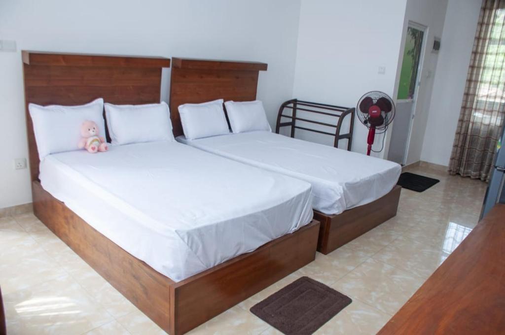 two beds in a bedroom with a doll sitting on them at Apartment Room - Mathara in Matara