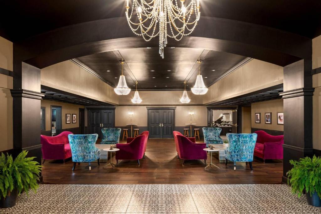 a large room with tables and chairs and a chandelier at The Highlander Hotel, Ascend Hotel Collection in Iowa City