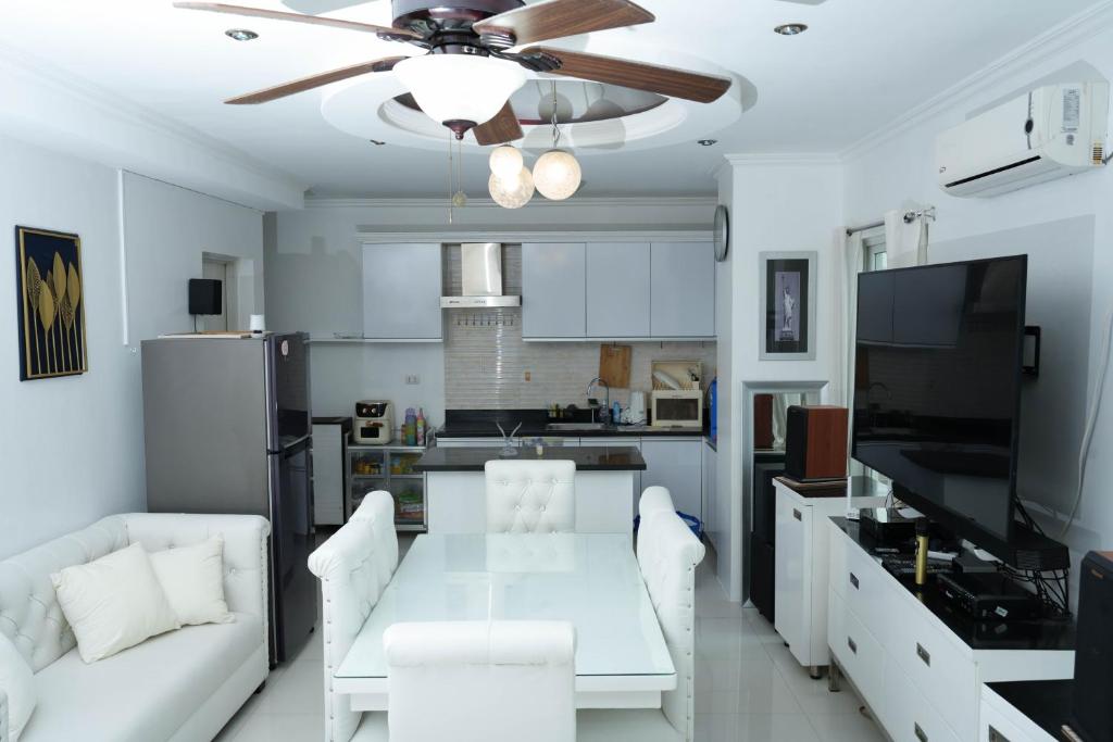 a living room with a white table and a ceiling fan at One Bedroom Condominium at Kandi Tower 2 in Angeles