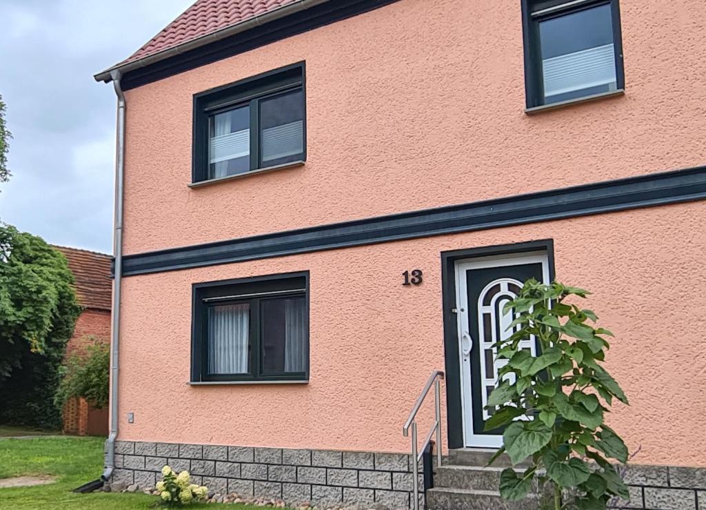 a pink house with the number on it at Ferienwohnung Havelnixe in Bahnitz