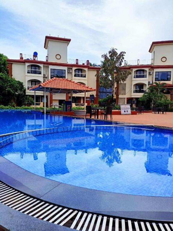 a large swimming pool in front of a building at Sun City Resort in Calangute