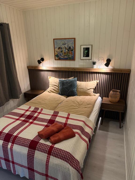 a bedroom with a large bed with a plaid blanket at Odinbua, ditt Lofoten-eventyr starter her in Stamsund