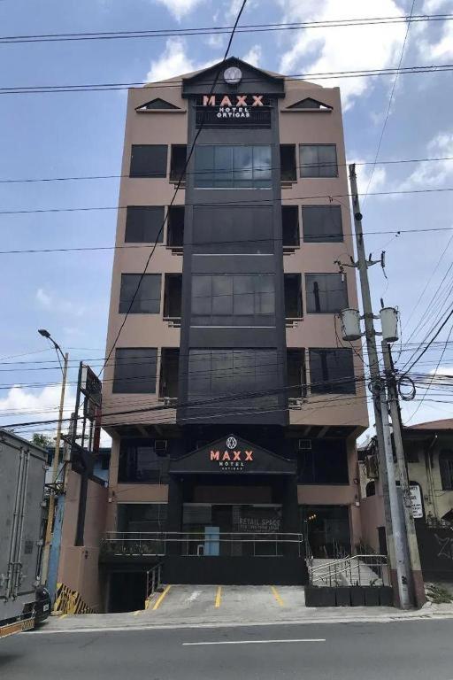 a tall building with a clock on top of it at Maxx Hotel Ortigas in Manila