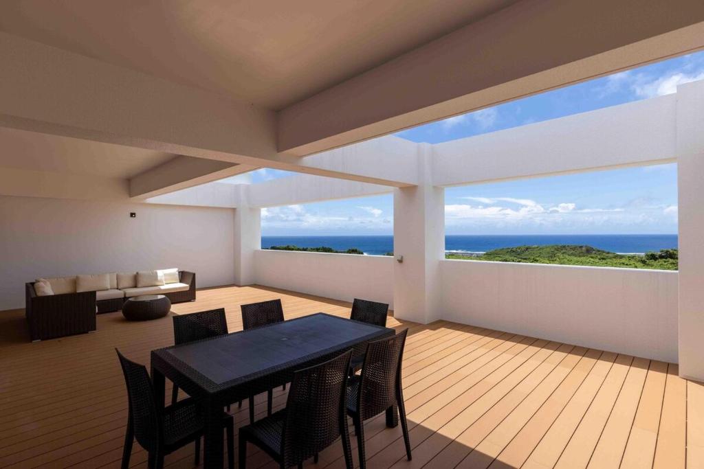 Miyakojima宮古島の美しい海と自然を一望できる絶景リゾートヴィラ的一间带桌子并可欣赏海景的餐厅