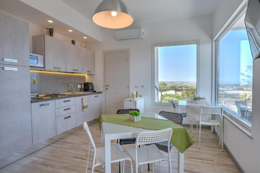 a kitchen and dining room with a table and chairs at Villa Vani Guest House in Marina di Ragusa