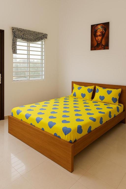 a bedroom with a bed with a yellow and blue comforter at Cozy studio I with AC and fan in Akassato