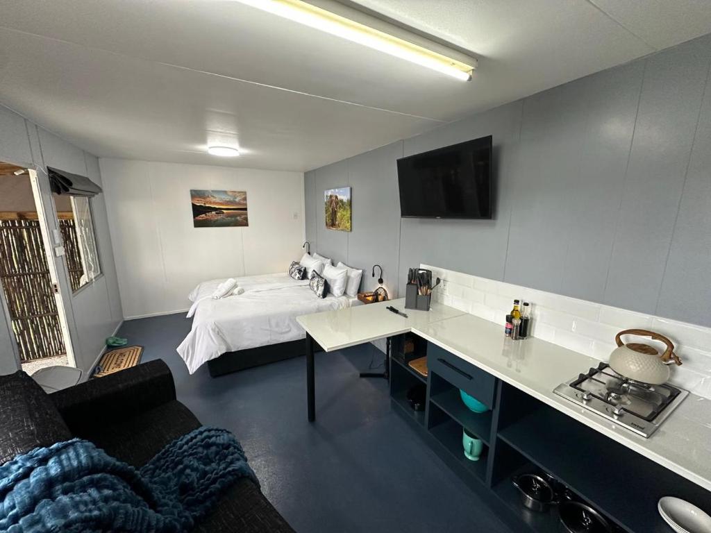 a bedroom with a bed and a desk in a room at Sundays River Adventures Cottages in Gqeberha