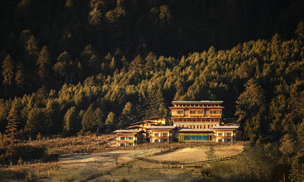 une grande maison au milieu d'une montagne dans l'établissement Taj Gangtey Resort and Spa Bhutan, à Tshalunang