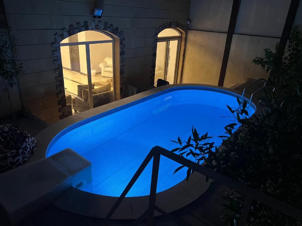 a large blue swimming pool in a house at night at luxury dublex with private swimming pool in Obour
