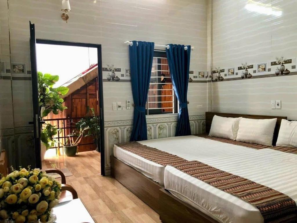 une chambre avec un lit, des rideaux bleus et une fenêtre dans l'établissement Happy Heart Homestay - Nhà số 07 bản Lác, à Mai Châu