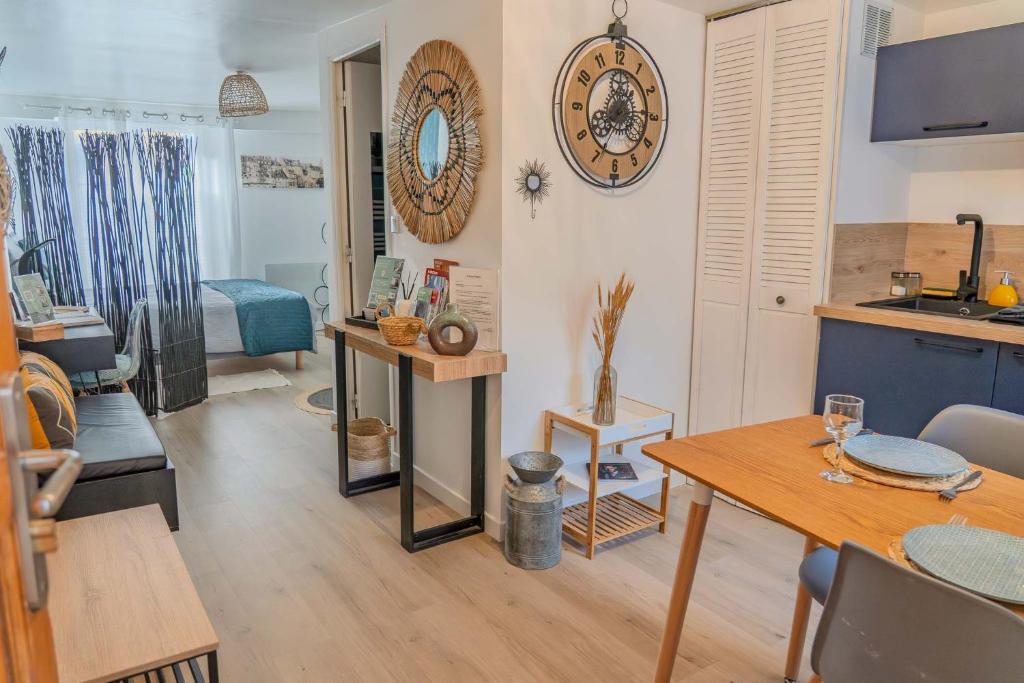 Una sala de estar con una mesa y una cocina. en L'Appart'Mans -charmant-studio-centre ville-2 pers, en Le Mans