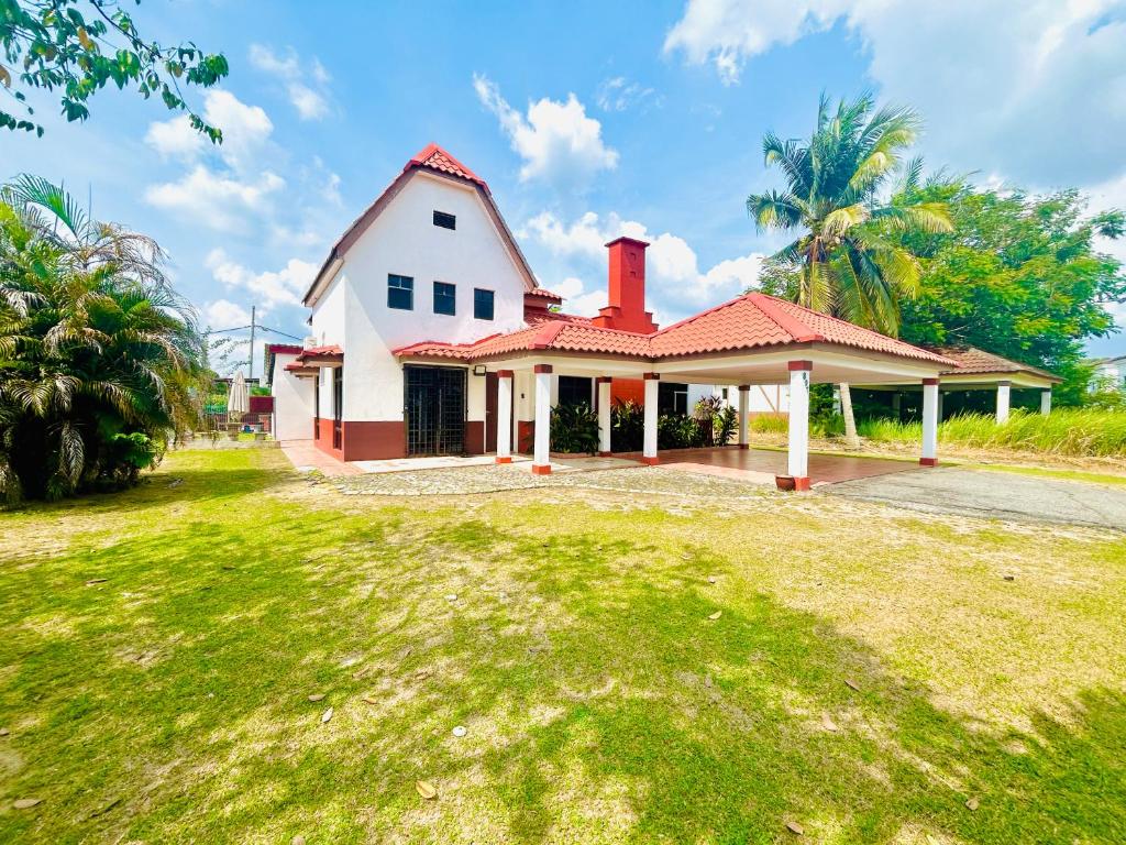 a large white house with a red roof at The 5R Famosa Villa in Kampong Ulu Pegoh