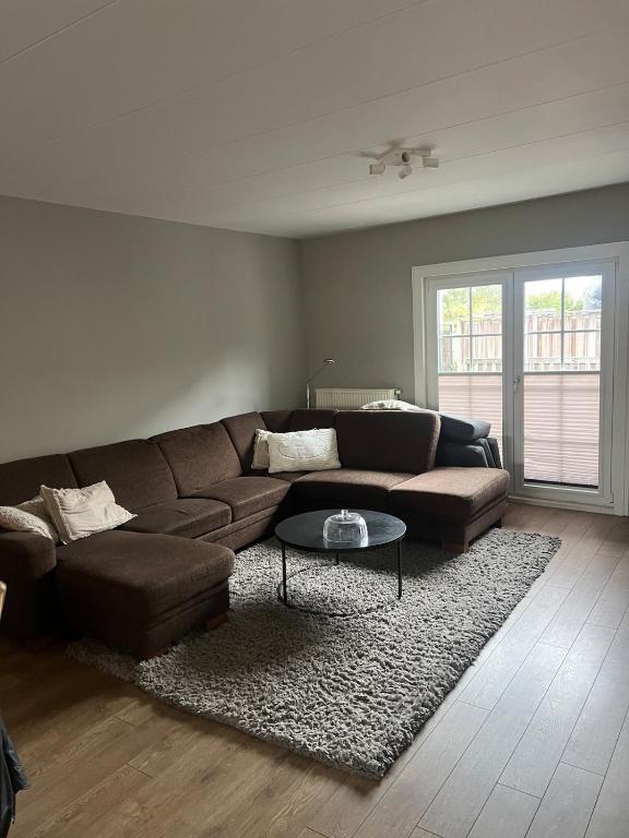 a living room with a brown couch and a table at Provence Driehuis Apartment in Driehuis