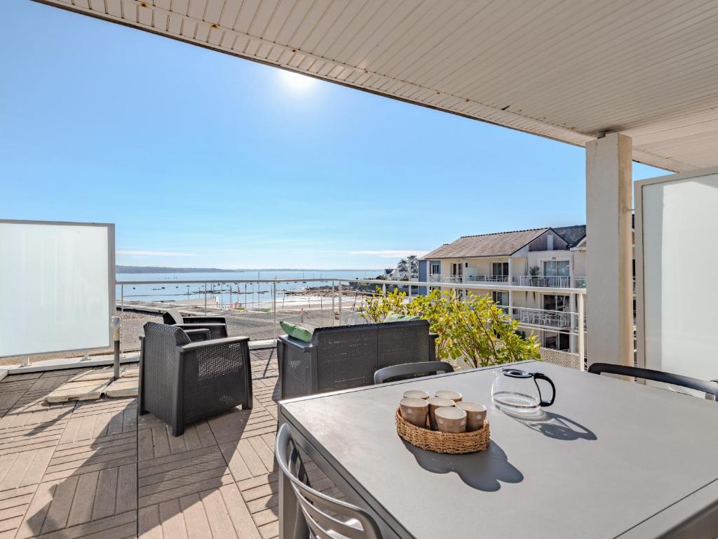 a balcony with a table and chairs and a view of the beach at D de Bertheaume N413 2P5 in Plougonvelin