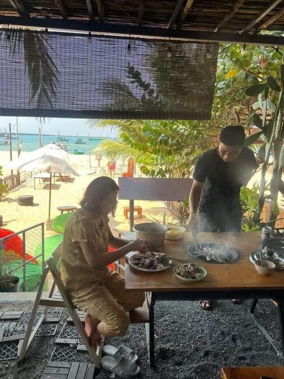 a man and a woman preparing food at a table at SOHO 1 PHÚ QUỐC in Phú Quốc