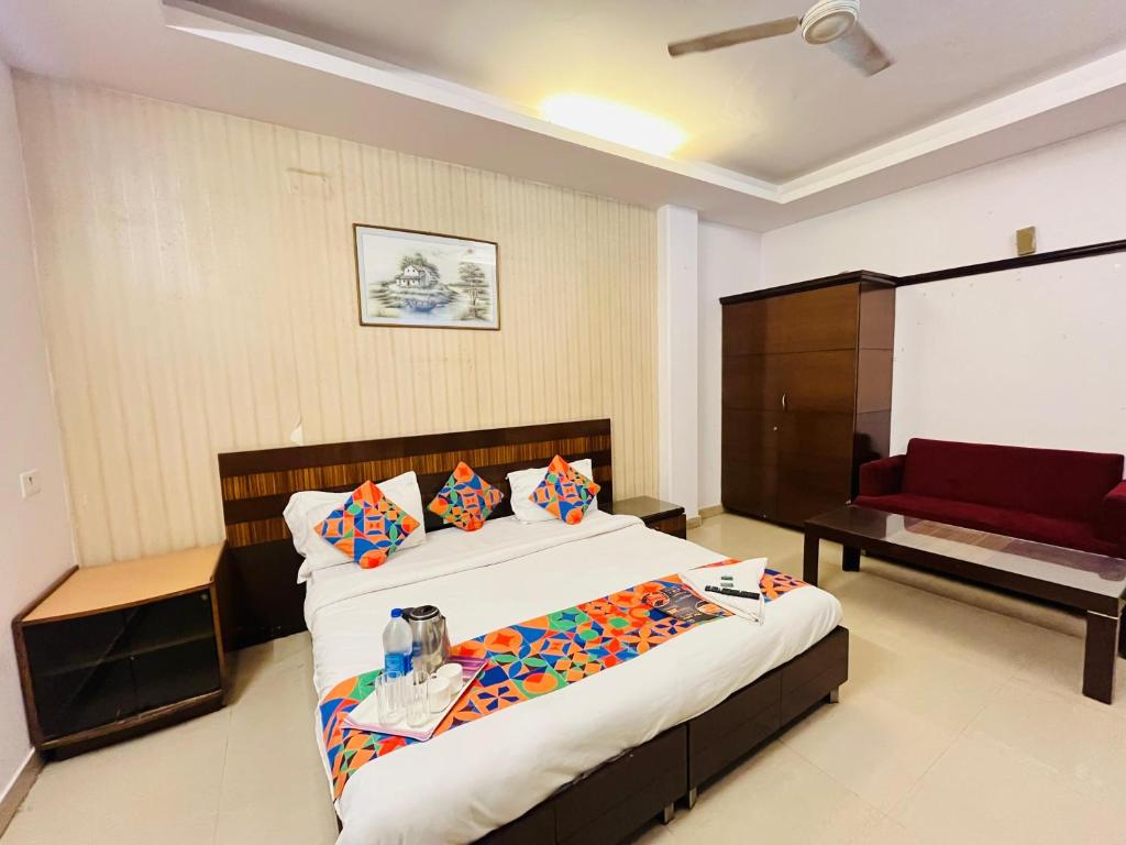 a bedroom with a large bed and a red couch at Hotel Krishana Near IIT Campus in Gurgaon