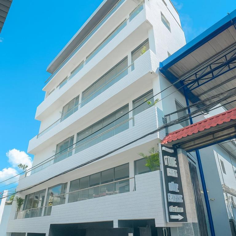 a white building with a sign in front of it at Moony Hotel Long Thành in Long Thành