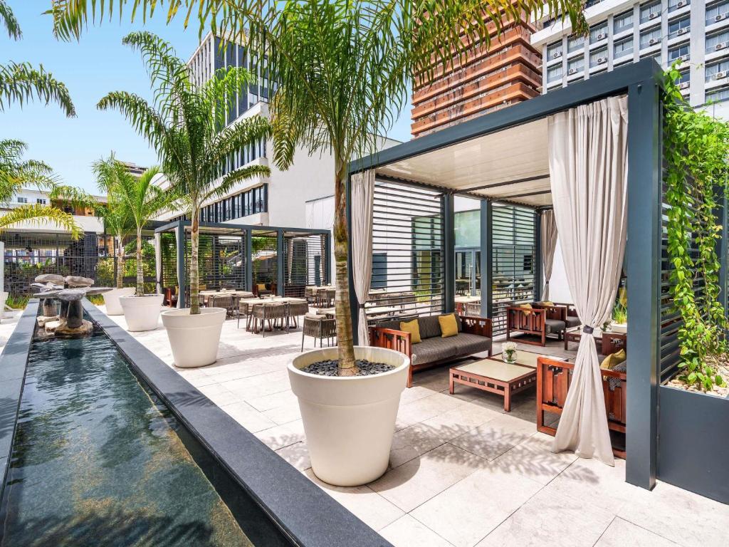 un patio al aire libre con piscina y un edificio en Movenpick Hotel Abidjan-Accor Group, en Abiyán