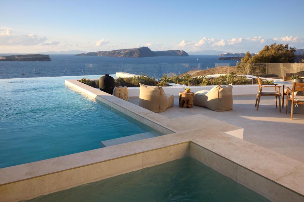 a swimming pool with a view of the water at Omna Caldera Suites in Akrotiri