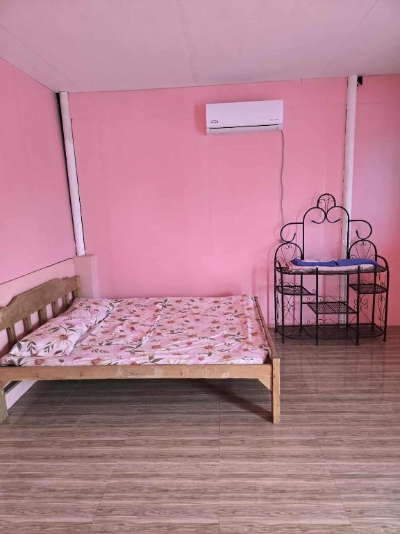 Bett in einem Zimmer mit einer rosa Wand in der Unterkunft Lola Mamang Resort in General Santos