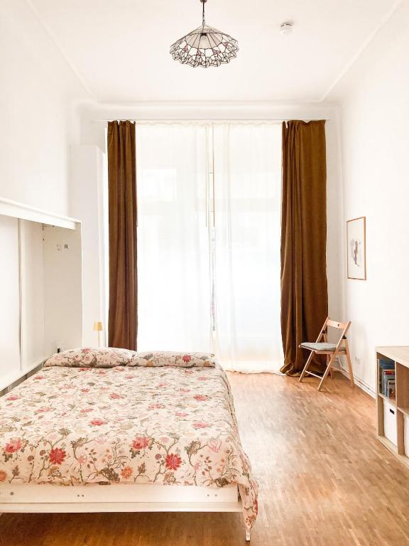 a bedroom with a bed and a large window at Sunny Renovated Ground-Floor Apartment in Neukölln in Berlin