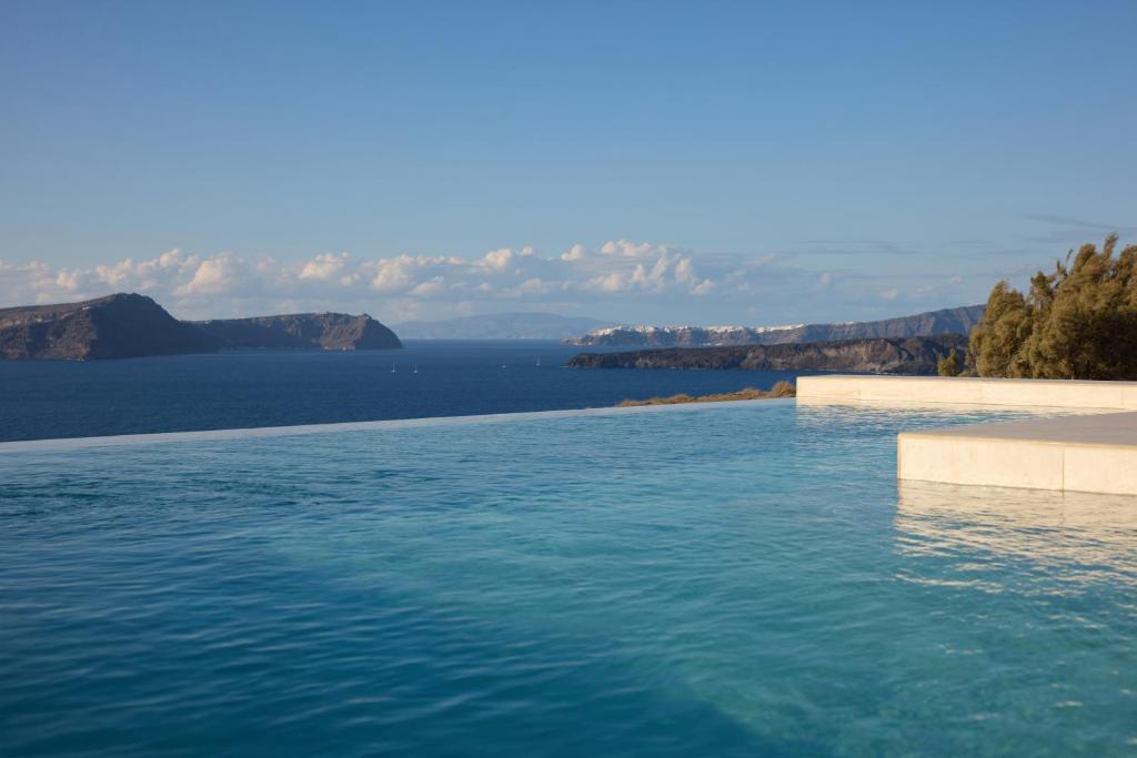 a swimming pool with a view of the water at Omna Caldera Suites in Akrotiri
