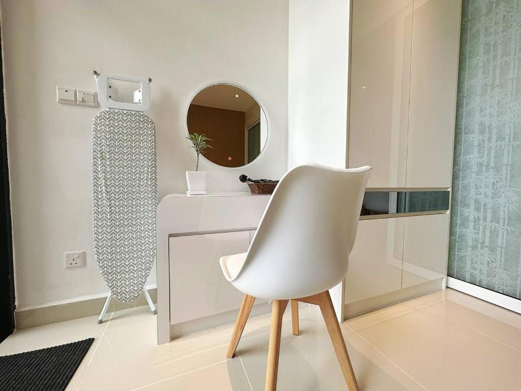 a white chair in a bathroom with a mirror at Summer Studio Apartment at Kota Kinabalu City Centre in Kota Kinabalu