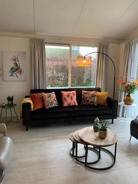 a living room with a black couch and a table at Bungalow 001 in Petten