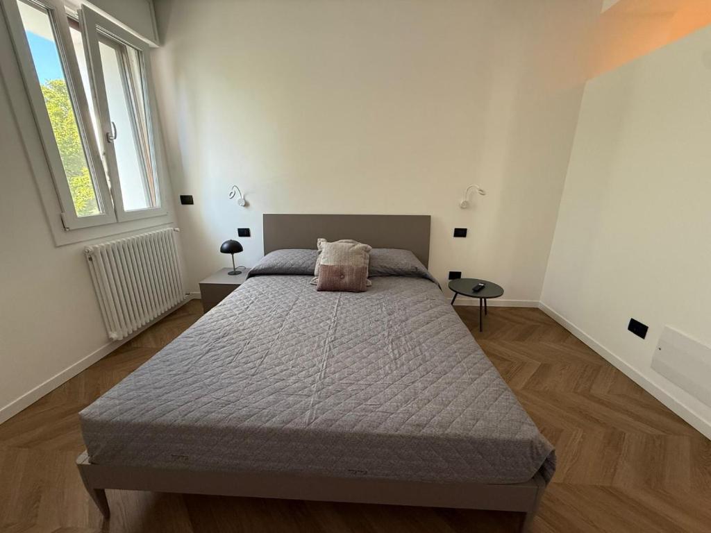 a bedroom with a large bed in a white room at Appartamento Verde in Pordenone