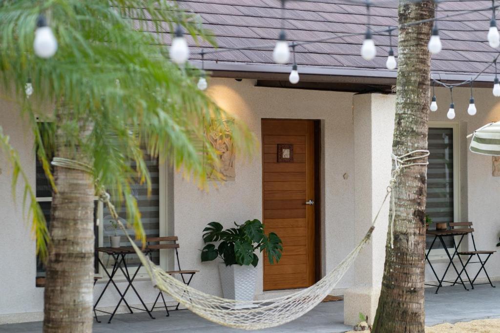 una hamaca frente a una casa con palmeras en Bali Slow Homestay, en Dongshan