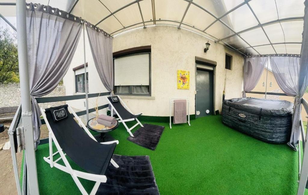 una casa con un pavimento verde e una stanza con un letto di LakePark Garden Villa with swimming pool & park a Bekecs