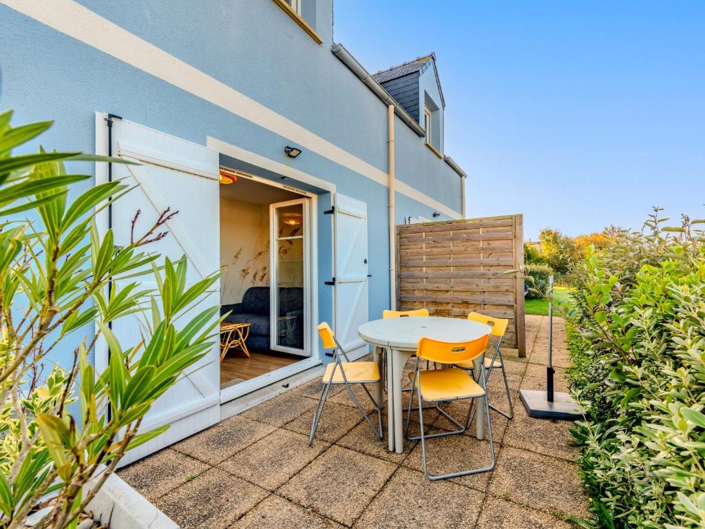 a patio with a table and chairs in front of a building at T de Pentrez N10 2P4 in Pentrez