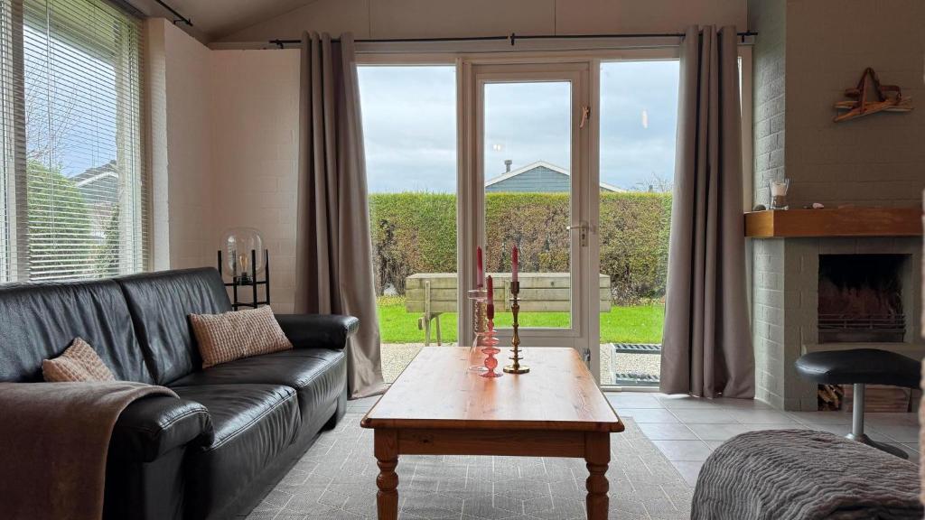a living room with a couch and a table at Bungalow 028 in Petten