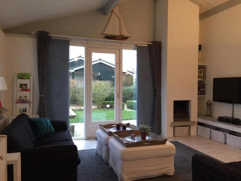 a living room with a couch and a large window at Bungalow 040 in Petten