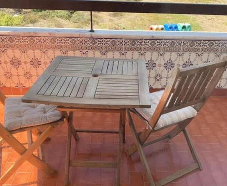una mesa de picnic y una silla en el patio en Canto Simples Rose, en Nazaré