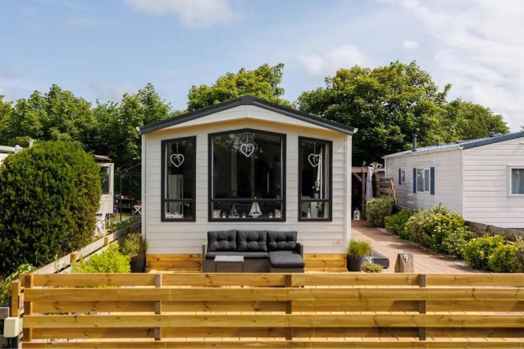 ein winziges Haus mit einer Couch auf einer Terrasse in der Unterkunft J 009 in Petten