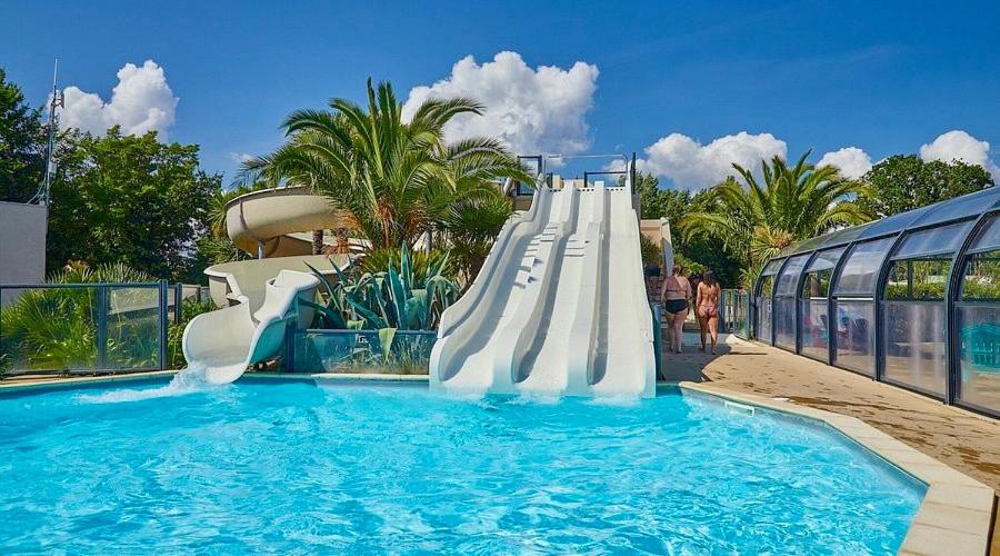 un tobogán de agua en una piscina de un complejo turístico en Mobil home spacieux 5 personnes à 15 min de Concarneau, en Trégunc