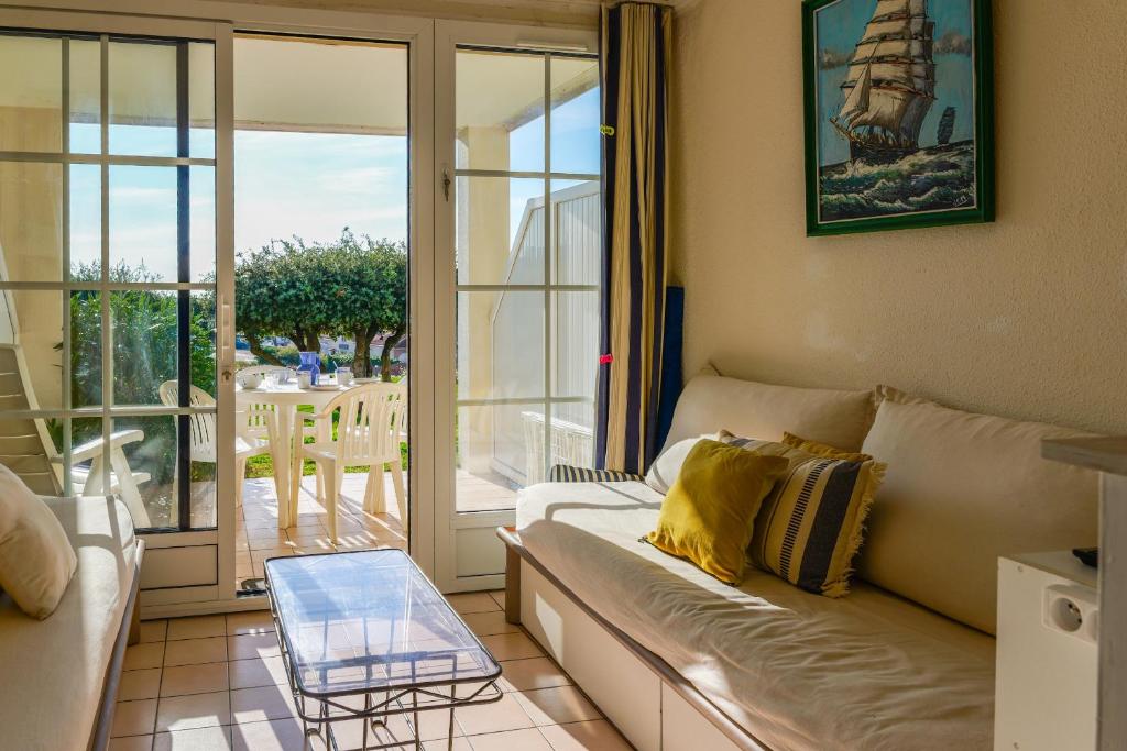 a living room with a couch and a glass table at Appartement en rdc - résidence la Goëlette Port Bourgenay - 4 personnes in Saint-Jean-dʼOrbetiers