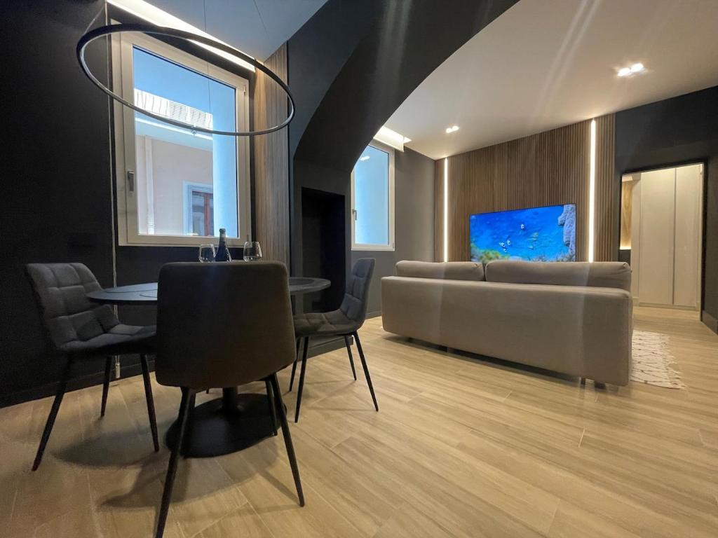 a living room with a couch and a table and chairs at Azulis Terme Suite 1 - luxury renovated accommodation in Olbia Center with garden in Olbia