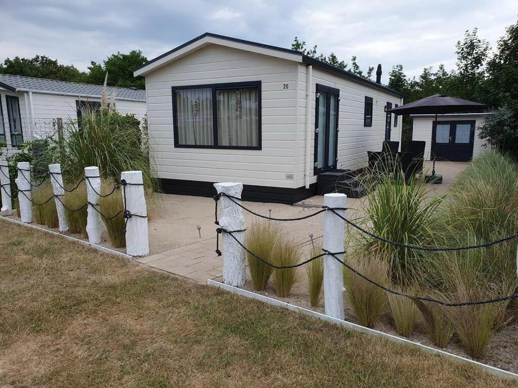 ein Haus mit einem Zaun vor dem Garten in der Unterkunft J 020 in Petten