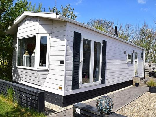 ein kleines weißes Haus mit Fenstern zu einem Hof in der Unterkunft J 062 in Petten