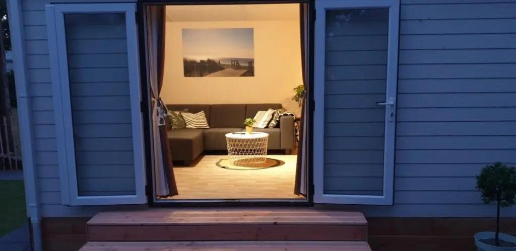 eine offene Tür zu einem Wohnzimmer mit einer Couch in der Unterkunft J 071 in Petten