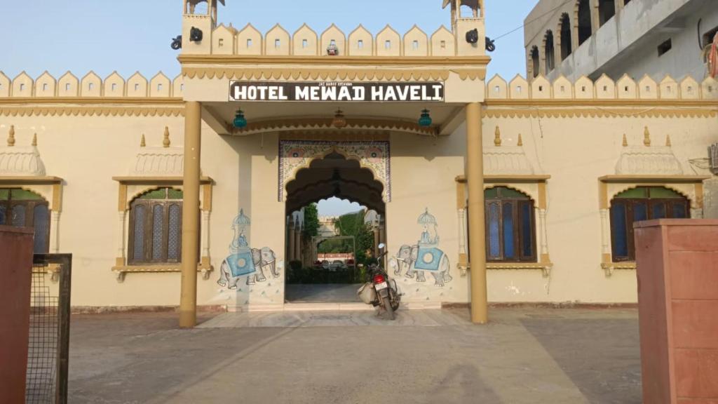 a gate to a building with a motorcycle parked in it at Hotel Mewad Haveli Pushkar in Pushkar