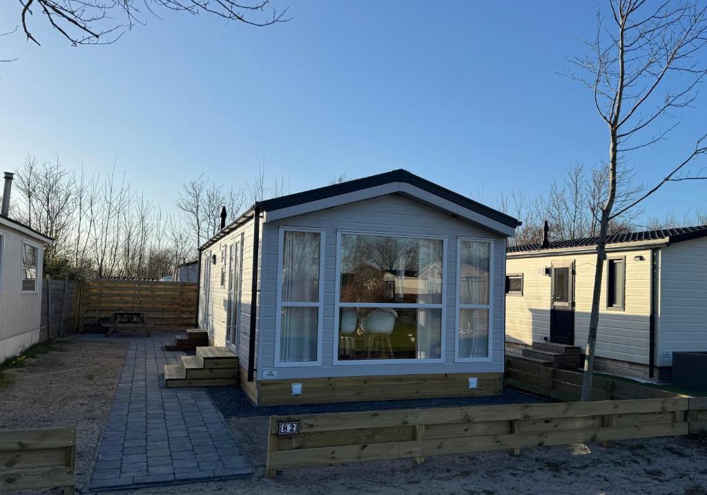 a small house with a window on a patio at Chalet 82 in Petten