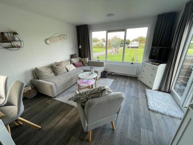 a living room with a couch and a table at Chalet 130 in Petten