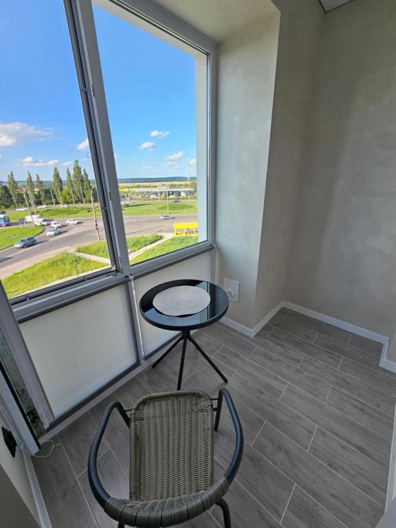 une chambre avec une table et une chaise devant une fenêtre dans l'établissement Квартира в Рівному біля луцького кільця, à Rivne