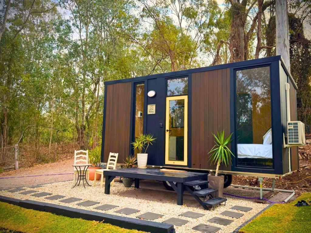 ein kleines Haus mit einem Tisch auf einer Terrasse in der Unterkunft Tranquility Ranch by Tiny Away in Wolfdene