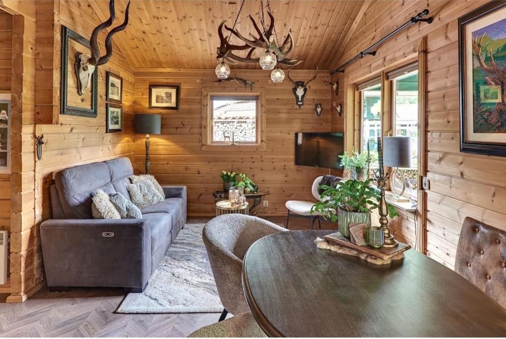 un soggiorno con un divano e un tavolo di Rustieke Finse Retreat met Houtkachel en Bar, Aan Bos en Strand! a Hulshorst