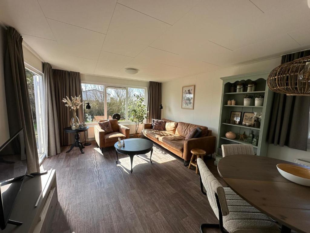 a living room with a couch and a table at Chalet 218 in Petten