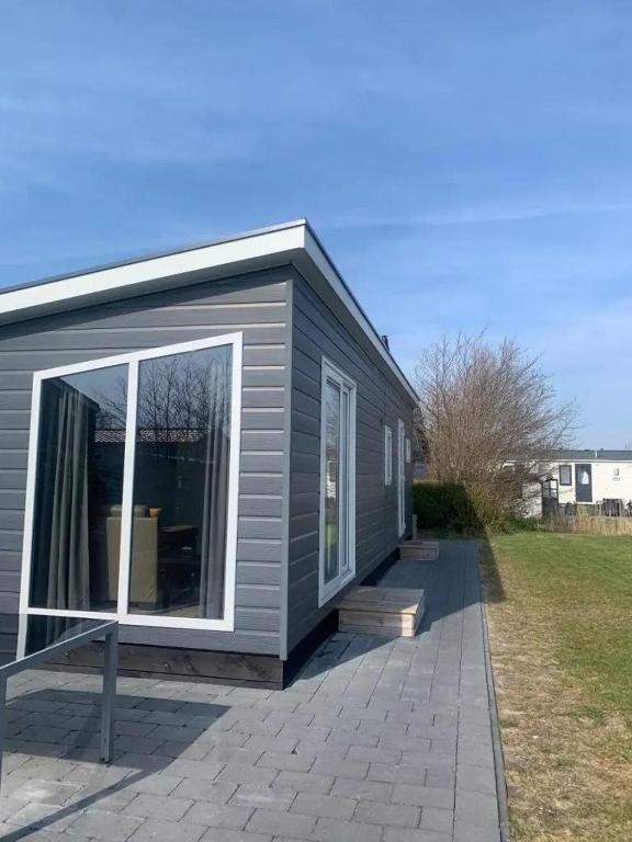 ein graues Haus mit einem großen Fenster zur Terrasse in der Unterkunft J 106 in Petten